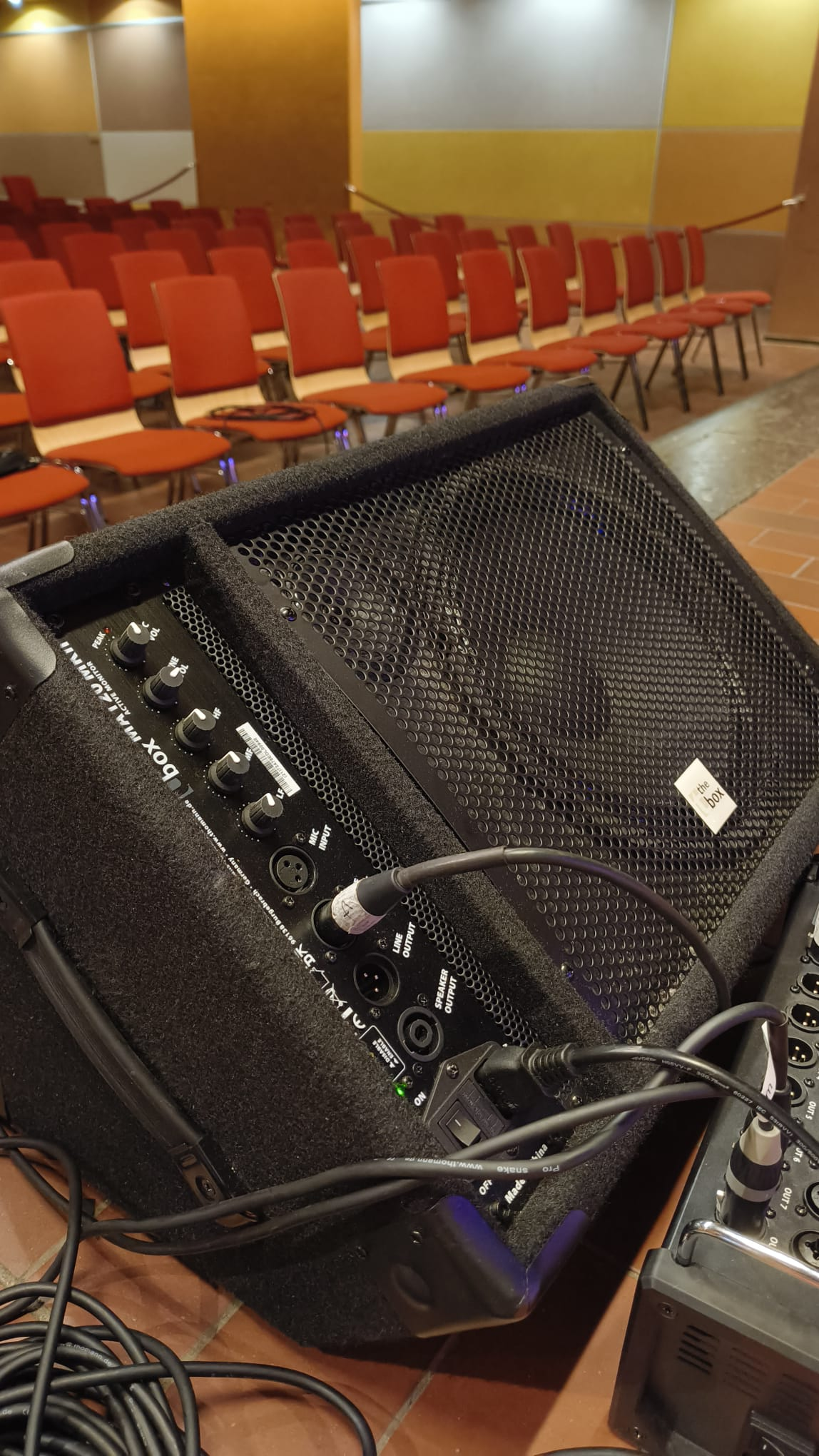 Nahaufnahme eines Bühnenmonitors mit XLR-Kabeln